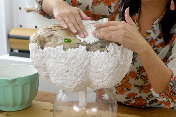 Once dry, place the pumpkin upside down in a bowl. Add paper mache to the bottom, and let dry completely again.