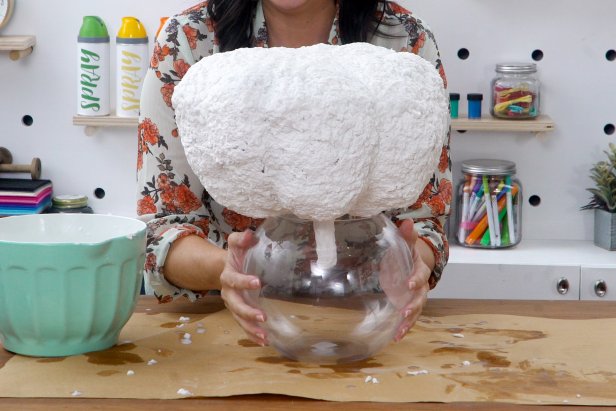 Once dry, place the pumpkin upside down in a bowl. Add paper mache to the bottom, and let dry completely again.