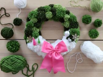 Green and white wreath with a pink bow and mini Christmas trees 