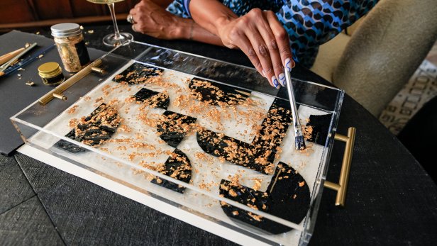 CH mixes gold foil pieces into resin with paint brush