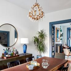Eclectic Dining Room With Blue Trim and Dainty Chandelier