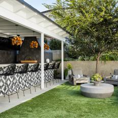 An Outdoor Kitchen Features Black and White Tile and Modern Light Fixtures