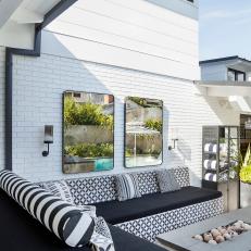 A Vibrant Back Patio Features a Tiled, Built-in Bench That Surrounds a Modern, Poolside Fire Pit