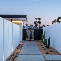 A concrete Paver Walkway Leads the Front Door of a Contemporary Villa That's Surrounded by Water-Wise Landscape
