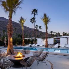 A Contemporary Outdoor Oasis Features a Large Swimming Pool, a Fire Pit and Lounge Area and Plenty of Palm Trees and Umbrellas That Create Shade for the Backyard Space