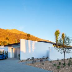 A Modern Stucco Villa Sits Beneath Desert Hills and Is Surrounded By Palm Trees and Water-Wise Landscaping