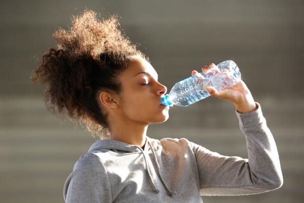 Woman Drinking Water To Stay Hydrated After Workout