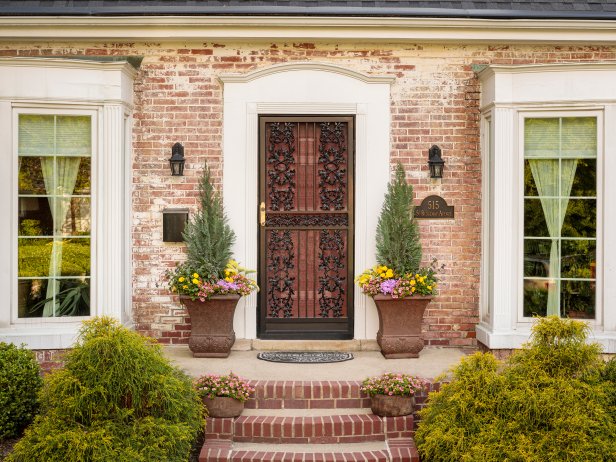 Iron Front Door Flanked by Tall Planters With Plants