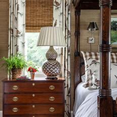 Traditional Bedroom With Woven Shade and Dark Bedside Dresser 