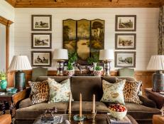 Earth toned hunting themed room with patterned throw pillows and art.
