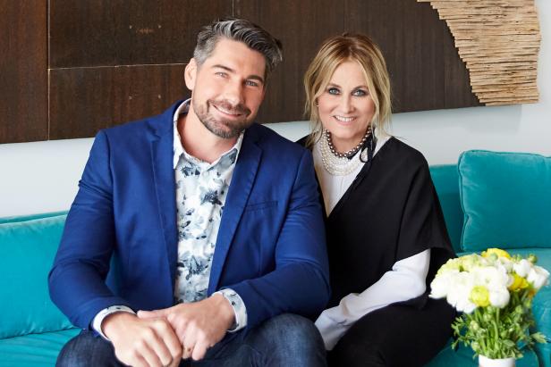 Hosts Dan Vickery (L) and Maureen McCormick sit in on the turquoise sofa in front of the Laguna Beach topography piece that Dan put together using the home's original wood for Greg and Liz's newly renovated living room, as seen on HGTV's Frozen in Time. (portrait)