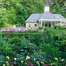 A Backyard Garden Features Vibrant Garden Beds and a Large Stone Garden House