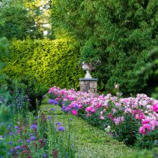 Tiered Garden Beds Feature Bright Flowers, Manicured Shrubs and a Flagstone Column