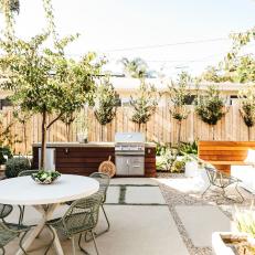 Modern Cement Slab Patio Features an Outdoor Kitchen and Multiple Sitting Areas