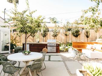 Modern Patio Features an Outdoor Kitchen and a Round Table and Chairs