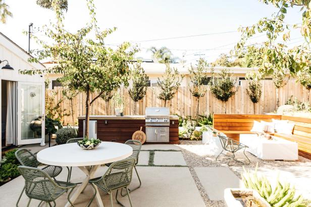 Modern Patio Features an Outdoor Kitchen and a Round Table and Chairs
