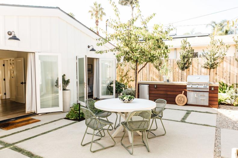Backyard Features a Patio, Dining Furniture and an Outdoor Kitchen 