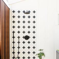 Modern Outdoor Shower Features a Black and White Tile and Black Fixtures