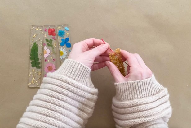 Once the bookmarks are dry, pull the tassel thread through the small hole at the top of the mold and tie a knot.