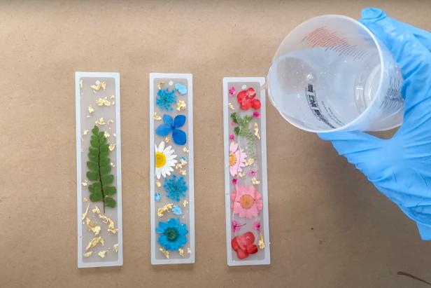 Once the resin is mixed according to the instructions, gently pour a thin layer of resin into one mold at a time. Tip: if the flowers move around, simply adjust with the tweezers. After you pour, add a little more resin to any areas that need little more resin.