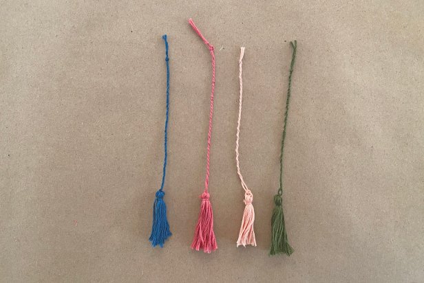 Twist the string for about 4’’ then tie off. Once the bookmarks are dry, pull the tassel thread through the small hole at the top of the mold and tie a knot.