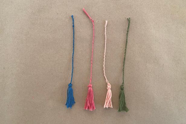 Twist the string for about 4’’ then tie off. Once the bookmarks are dry, pull the tassel thread through the small hole at the top of the mold and tie a knot.