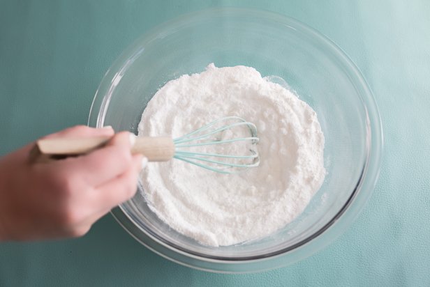 Use a whisk to mix ingredients together well to avoid any lumps. Next, measure 1 Tbs. of fractionated coconut oil. While stirring the dry mixture with the whisk, pour a little bit of the oil into the bowl. Add a little bit more of the oil while continuing to whisk until 1 Tbs. is incorporated. Then, measure out 1 Tbs. and repeat the steps above until 2 Tbs. have been added to the mixture and combined.