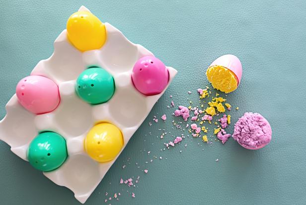 HGTV Handmade's Jill Tennant shows you how to make this cute, colorful Easter egg bath bomb in minutes. To make, you will need 12 plastic egg molds, an egg carton, four large bowls, a spray bottle, a whisk, spoon and fork, witch hazel, baking soda, epsom salt, citric acid, cornstarch, fractionated coconut oil, plant-based food coloring and essential oil.