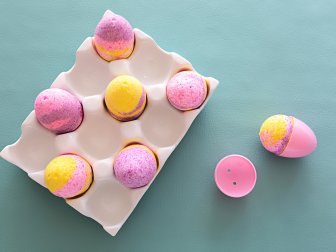 Easter Egg Bath Bombs Sit in Egg Carton on Table Beside One in Mold