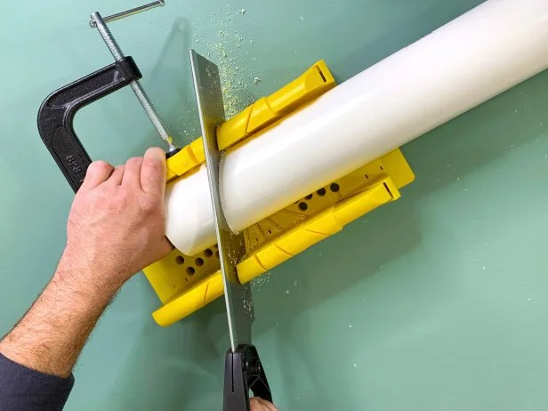 Man sawing white PVC pipe