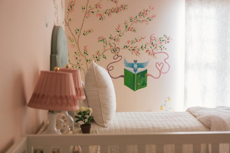 White bed with green headboard, and mural on pink walls with bird. 