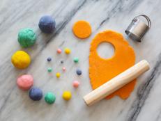 Colorful Balls of Homemade Play Dough on Table Near Rolling Pin