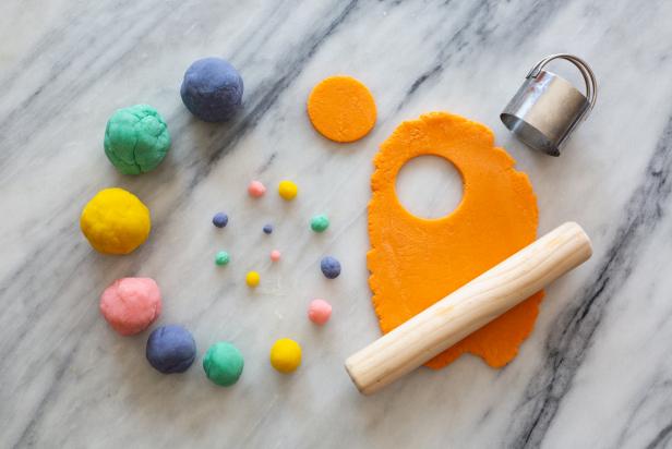 Colorful Balls of Homemade Play Dough on Table Near Rolling Pin