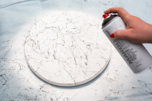 For the top of the table, use a 15’’ wooden round. Start by using white spray paint or latex paint to prime and paint the table top. Next, use marble spray paint to add an elegant marble-inspired effect. Last, finish the table top with 2-3 coats of clear acrylic spray. Let it dry completely.