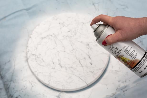 For the top of the table, use a 15’’ wooden round. Start by using white spray paint or latex paint to prime and paint the table top. Next, use marble spray paint to add an elegant marble-inspired effect. Last, finish the table top with 2-3 coats of clear acrylic spray. Let it dry completely.