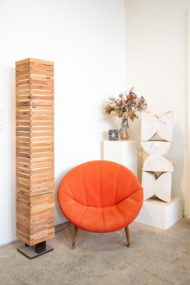 Orange Cushion Chair in Studio Vignette With Stacked Wood Art