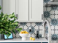 Smart home technology elevates the faucet in this kitchen while striking blue and white tile enhances the backsplash and adds a stylish texture to the space.