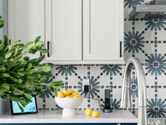 Smart home technology elevates the faucet in this kitchen while striking blue and white tile enhances the backsplash and adds a stylish texture to the space.
