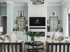 Pops of black help modernize this coastal living room while natural scientific drawings of sea life and shells add a sense of place and anchor the fireplace on each side.