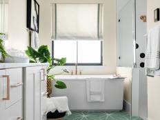 The main suite bathroom is a relaxing haven in soothing tones of white and soft seaglass green. A large soaker tub is the perfect spot to wash away the day’s stresses while rose gold accents add a chic, modern twist to the inviting space.