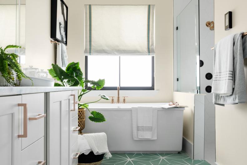 The main suite bathroom is a relaxing haven in soothing tones of white and soft seaglass green. A large soaker tub is the perfect spot to wash away the day’s stresses while rose gold accents add a chic, modern twist to the inviting space.