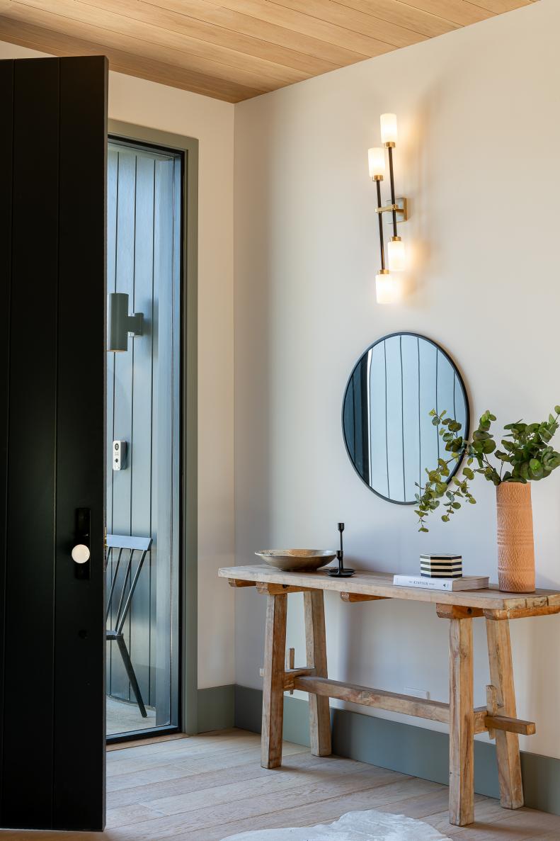 This minimalistic foyer includes a modern sconce.