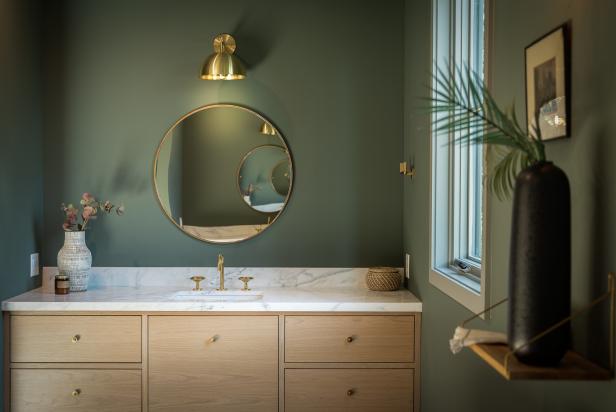 This bathroom features green walls and a marble sink vanity.