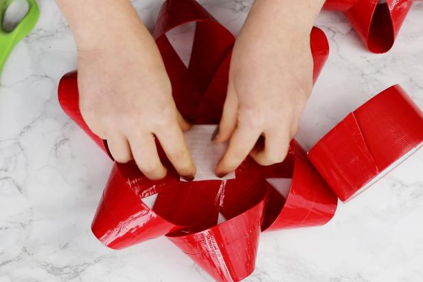 Use more loops of tape to stack the three sections to make a gift bow. Use additional tape as needed to keep all of it secure.