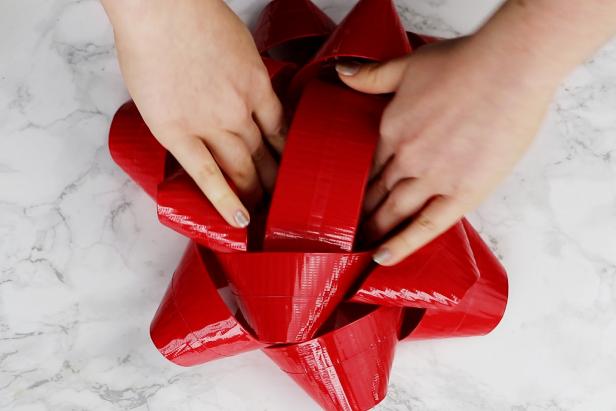 Use more loops of tape to stack the three sections to make a gift bow. Use additional tape as needed to keep all of it secure.