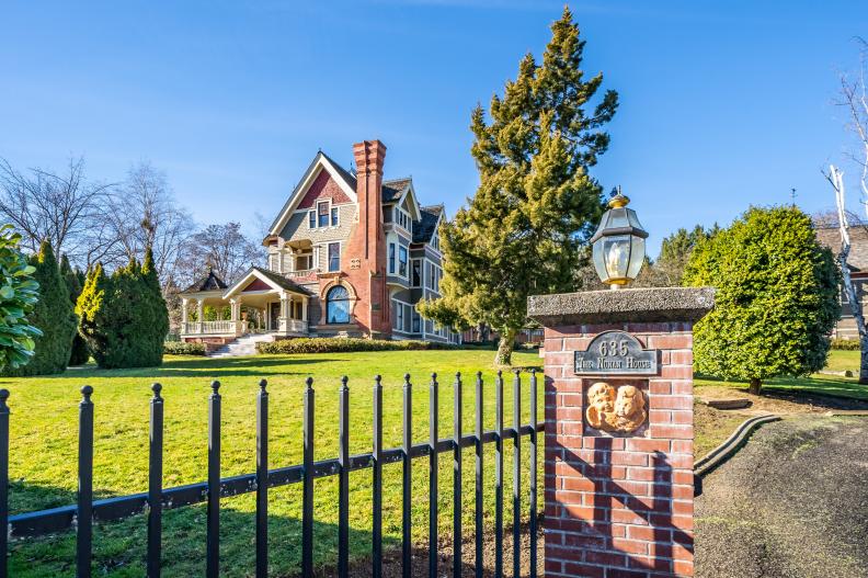Victorian-Style Home With Wrought Iron Fence and Yard