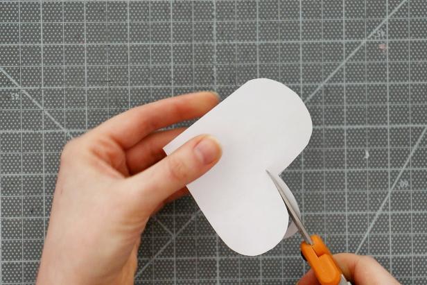 Trace one heart onto scrap paper and cut it out. Cut off about ⅛” all the way around to make a slightly smaller heart pattern. Trace this onto a second color of paper and cut out 8 hearts. You can also cut out a square that fits in the center of the card.