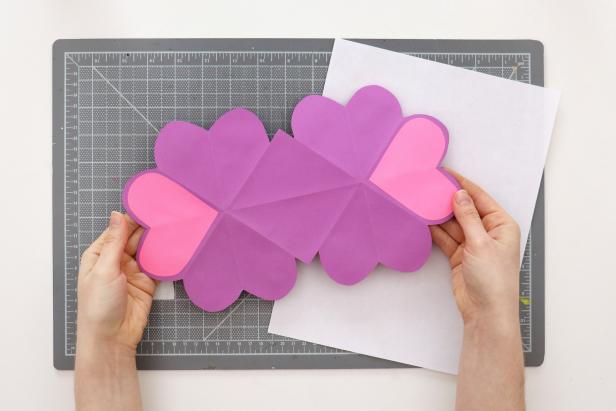Glue down all of the hearts and the center square. Glue the two extra hearts onto the back of the card.