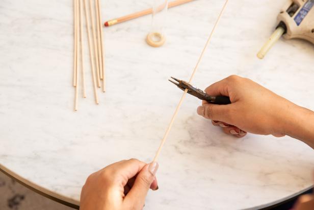 Measure the wooden dowel against the glass test tube to determine length and mark with a pencil. Then trim the dowel with needle nose pliers.