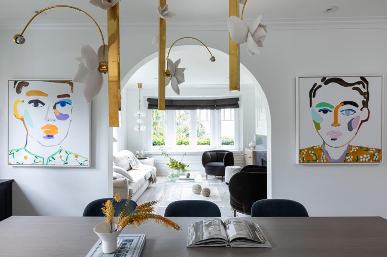 Colorful painted portraits frame a dining room's arched entrance